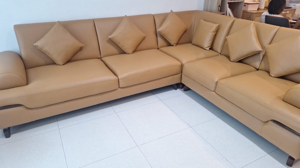 A tan L-shaped leather sofa with matching cushions, showcasing a coordinated upholstery finish. This image is suitable for a sofa cover replacement or leather sofa upholstery project gallery in Dubai.
